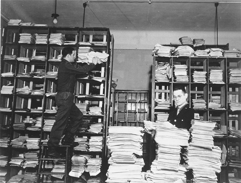 des membres du personnel de l'armée américaine organisent des piles de documents allemands recueillis par les enquêteurs sur les crimes de guerre comme preuves pour le tribunal militaire international. des membres du personnel de l'armée américaine organisent des piles de documents allemands recueillis par les enquêteurs sur les crimes de guerre comme preuves pour le tribunal militaire international.